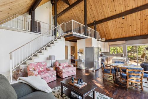ein Wohnzimmer mit einer Treppe und einem Tisch in der Unterkunft Warm and Cozy Mountain and Lake View Haven cottage in Kelseyville