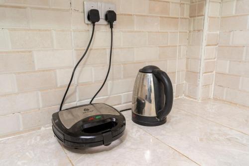 a toaster sitting on the floor next to a wall at Beths serviced apartments in Ruiru