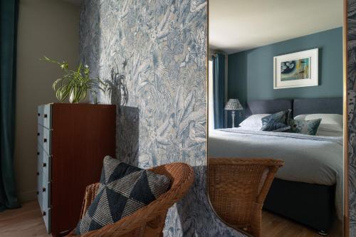 a mirror in a bedroom with a bed and a chair at Sunnybrook - A luxurious Carbon Neutral House close to beach, Shaldon in Shaldon