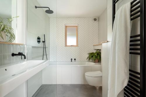 a bathroom with a tub and a toilet and a sink at Sunnybrook - A luxurious Carbon Neutral House close to beach, Shaldon in Shaldon
