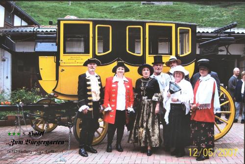 a group of people standing in front of a carriage at Hotel Zum Bürgergarten in Stolberg i. Harz