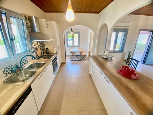 a kitchen with white cabinets and a counter top at Villa Elena - Private Villa in the heart of nature in Chania Town