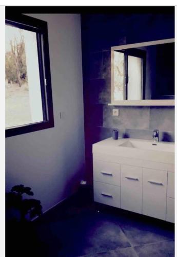 a bathroom with a white sink and a window at Appartement in Vignale
