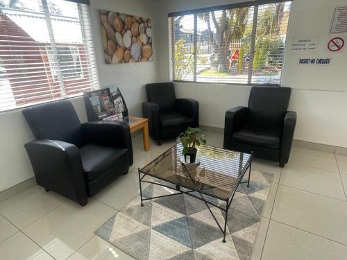 a waiting room with chairs and a table in a waiting room at Palmar Hotel in Johannesburg