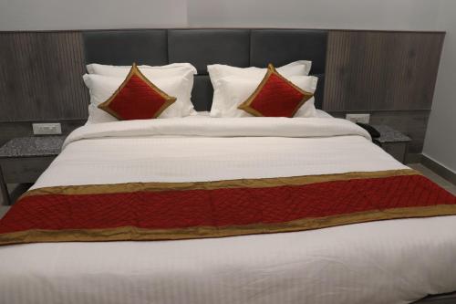 a large white bed with red pillows on it at The Byke Boutique - Amra Oasis Osian in Osiān