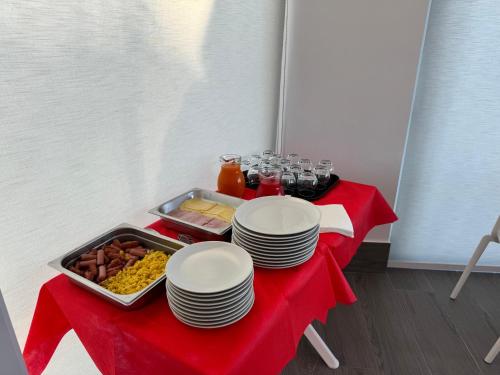 a table with a red table cloth with plates and food at Hotel Cocceio in Bacoli