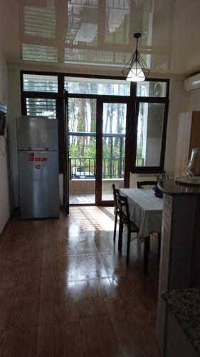a kitchen with a refrigerator and a table with chairs at Leto by Sveta in Ureki