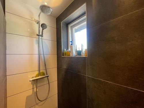 a bathroom with a shower with a window and a shower head at Wellness House in Frederikssund