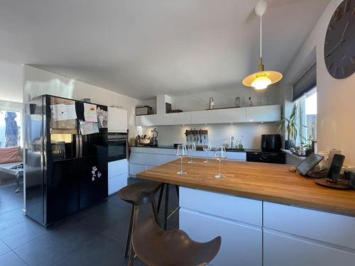 a kitchen with a wooden counter and a black refrigerator at Wellness House in Frederikssund