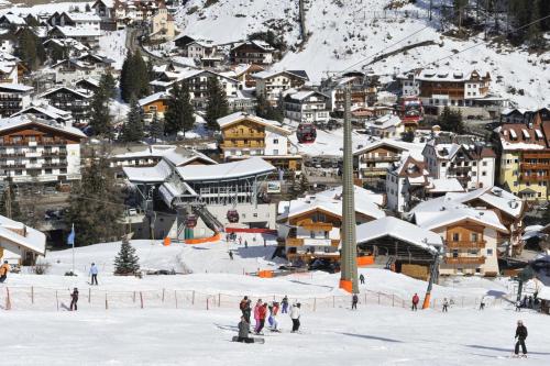 a group of people skiing on a snow covered mountain at Hotel Euròpa Dolomites in Selva di Val Gardena