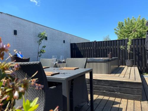 a patio with a table and chairs on a deck at Wellness House in Frederikssund