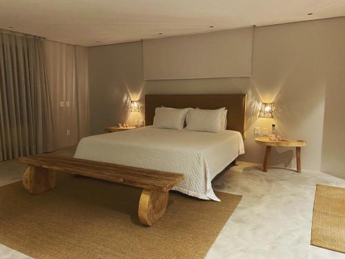 a bedroom with a bed and a wooden bench at Beach House Brazil in Amontada