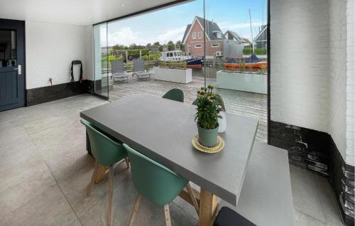 a dining table and chairs in a room with a patio at 3 Bedroom Awesome Home In Stavoren in Stavoren