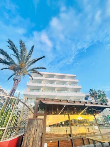 a building with a palm tree in front of it at Apartamentos Llobet Ibiza in Ibiza Town