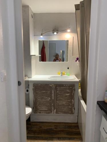 une salle de bain avec un lavabo et un miroir dans l'établissement Appartement Bandol 2 personnes voir 4, à Bandol
