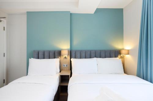 two beds sitting next to each other in a room at Prince William Hotel in London
