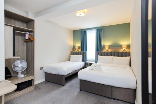 a hotel room with two beds and a window at Prince William Hotel in London
