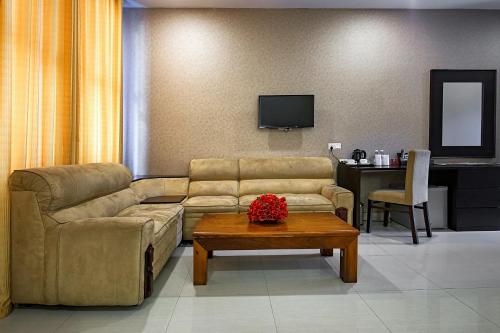 a living room with a couch and a table at The Full Moon Hotel Katunayake in Katunayake