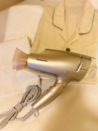 a hair dryer sitting on top of a bed at Hotel Monterey Sendai in Sendai