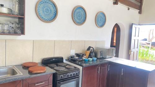 a kitchen with a stove and plates on the wall at Wide Horizons Mountain Retreat in Malkerns