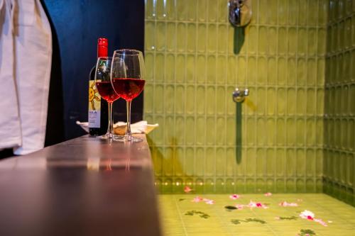 a bottle of wine and two glasses on a table at The Marwar Hotel & Gardens in Jodhpur