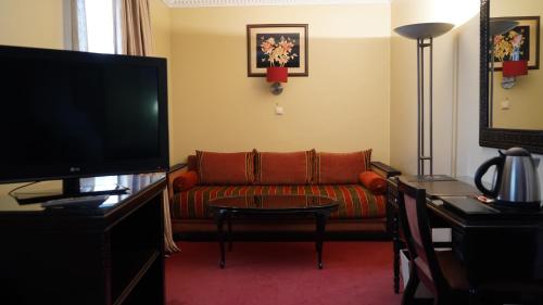 a living room with a couch and a television at Hotel Toubkal in Casablanca