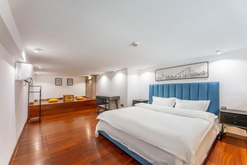 卓美雅酒店公寓（广州珠江新城店） في قوانغتشو: غرفة نوم بسرير كبير مع لوح رأس أزرق