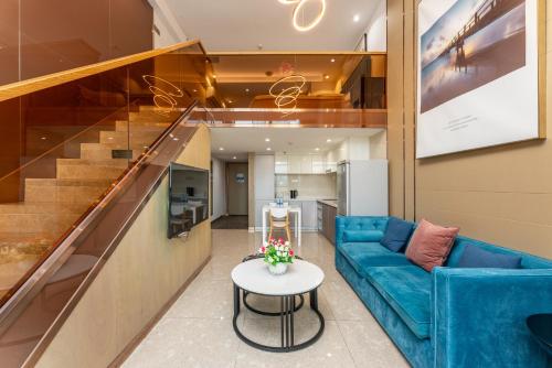卓美雅酒店公寓（广州珠江新城店） في قوانغتشو: غرفة معيشة مع أريكة زرقاء وطاولة