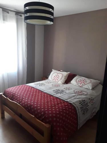 - une chambre avec un lit et une couette rouge et blanche dans l'établissement Maison de campagne, à Cieurac