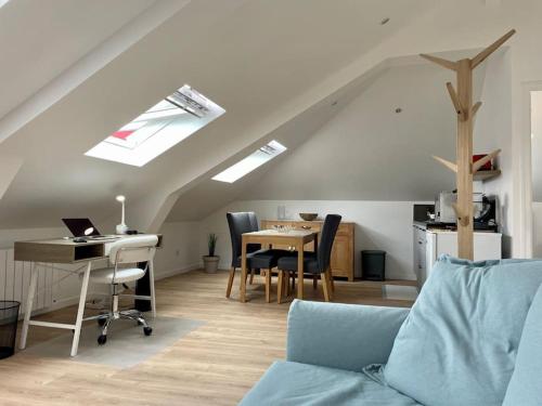 une chambre mansardée avec un bureau et une table avec des chaises dans l'établissement Rouen Préfecture - L'arrière Seine, à Rouen