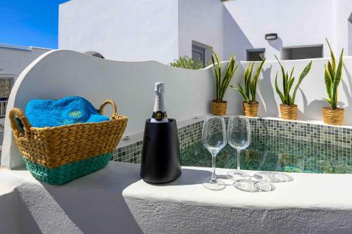 a table with a bottle of wine and two glasses at Margaret of Naxos in Agios Prokopios