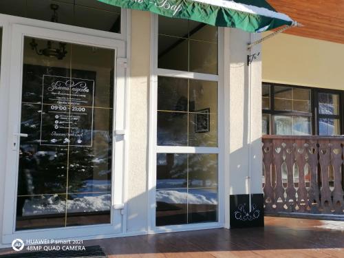 a store front with glass doors with a sign on it at Chalet Zolota Pidkova & River in Slavske