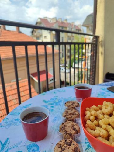 ソコバニャにあるSunrise apartment Sokobanjaのバルコニーにクッキーとコーヒーカップが置かれたテーブル