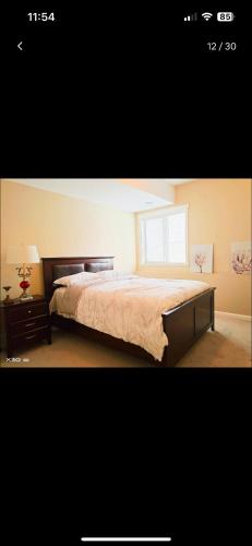 a bedroom with a bed and a window at Peaceful and Spacious Lake View in West Kelowna