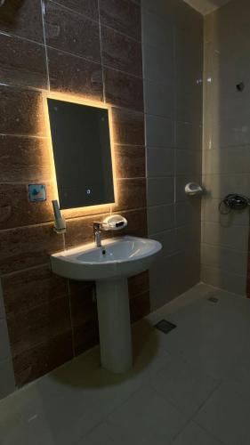 a bathroom with a sink and a television on the wall at Diva Hotel 2 in Jeddah