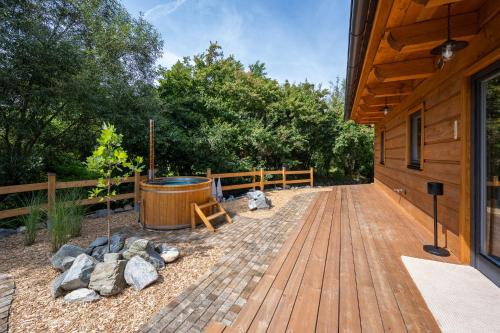 a wooden deck with a hot tub next to a building at Roubenka Sobotín in Sobotín