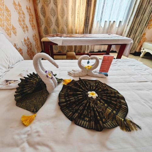 two swans are sitting on a bed with umbrellas at Golden Peacock Hotel Blantyre in Blantyre