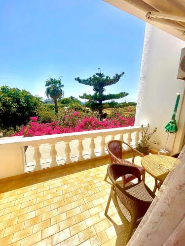 a balcony with a table and chairs and flowers at Irene Villa in Ierápetra