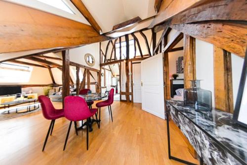 un salon avec des chaises rouges et une table dans l'établissement Gare - Le grenier de Beauvoisine, à Rouen