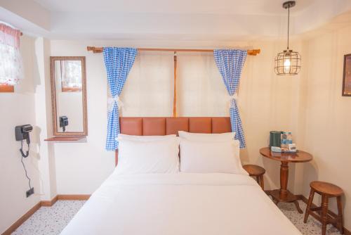 a bedroom with a large bed with blue and white curtains at JB Home Bangkok - Victory monument in Bangkok