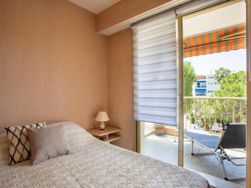 une chambre avec un lit et une grande fenêtre dans l'établissement Apartment L'Hippocampe by Interhome, à Cagnes-sur-Mer