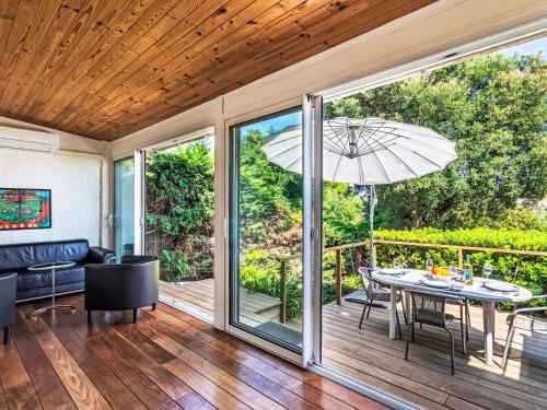 - une véranda avec une table et un parasol dans l'établissement Holiday Home Font Mourier-1 by Interhome, à Gassin