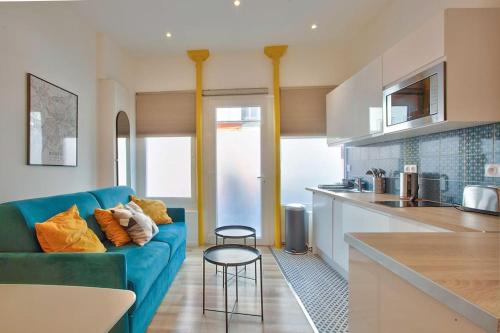 un salon avec un canapé bleu dans une cuisine dans l'établissement Gare - La Boutique Beauvoisine, à Rouen