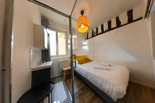 une petite chambre avec un lit et une fenêtre dans l'établissement Gare - La Boutique Beauvoisine, à Rouen