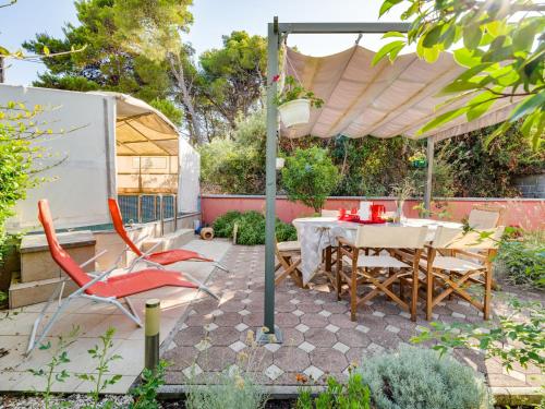 a patio with a table and chairs under an umbrella at Holiday Home Morski dragulj by Interhome in Vodice
