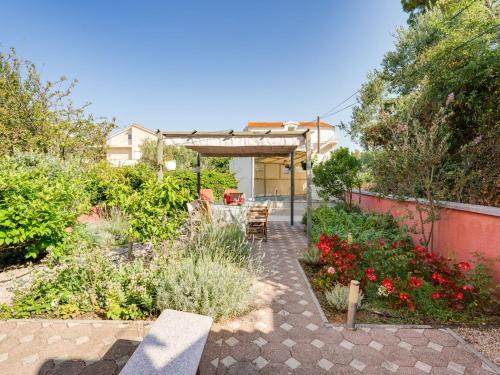 a patio with a table and chairs in a garden at Holiday Home Morski dragulj by Interhome in Vodice