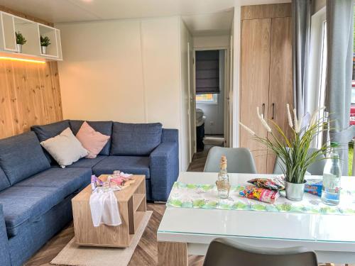 Una sala de estar con un sofá azul y una mesa. en Holiday Home Tiny Haus Weltenburg by Interhome, en Riedenburg