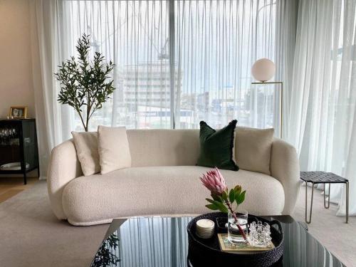 a living room with a couch and a large window at Beaumont Residence in Auckland