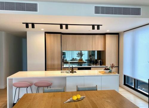 a kitchen with a wooden table and a counter top at Beaumont Residence in Auckland