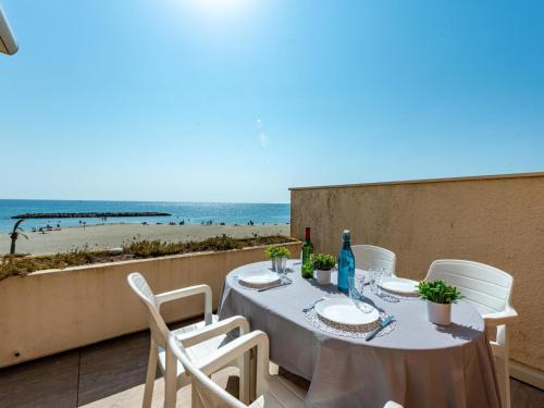une table sur un balcon avec vue sur la plage dans l'établissement Apartment le Grand Large-10 by Interhome, au Barcarès